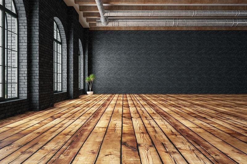 Salon z drewnianą podłogą i czarnymi ścianami